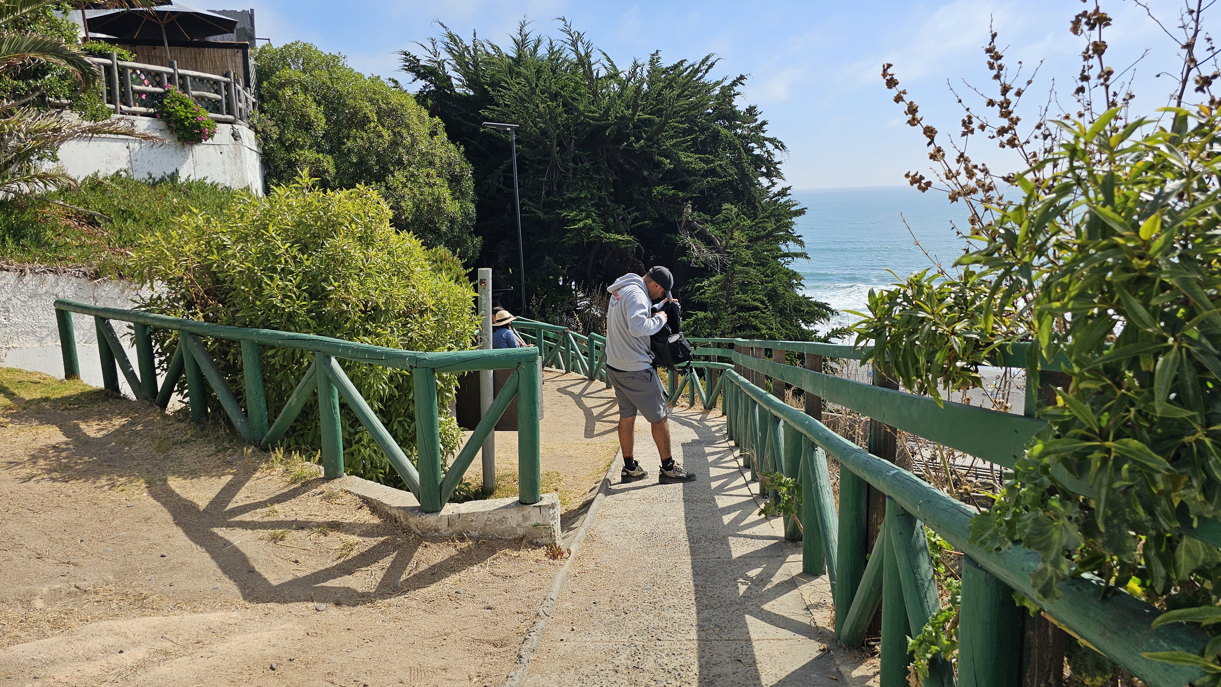 Fotografía del sendero al costado de la barandas verdes